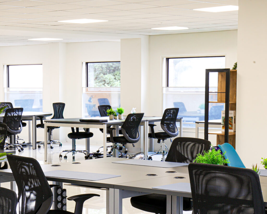 Bright, spacious open-plan serviced office with modern desks, ergonomic chairs, large windows and natural light, offering flexible workspace for growing businesses.